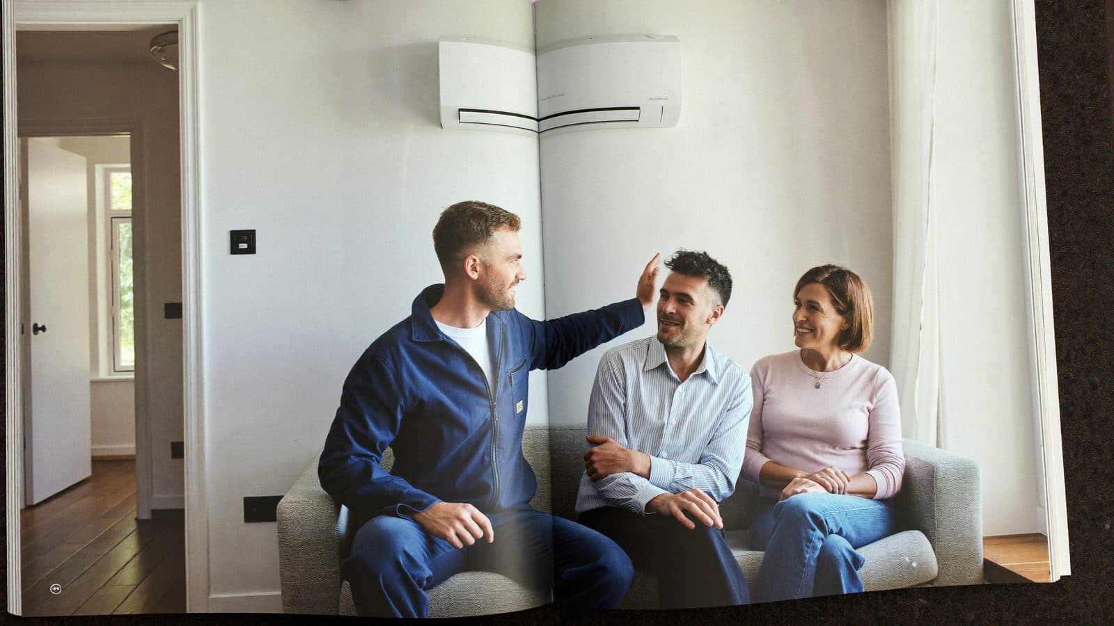 Monteur bespreekt met een stel de beste plek en het juiste vermogen voor hun airco in de woonkamer