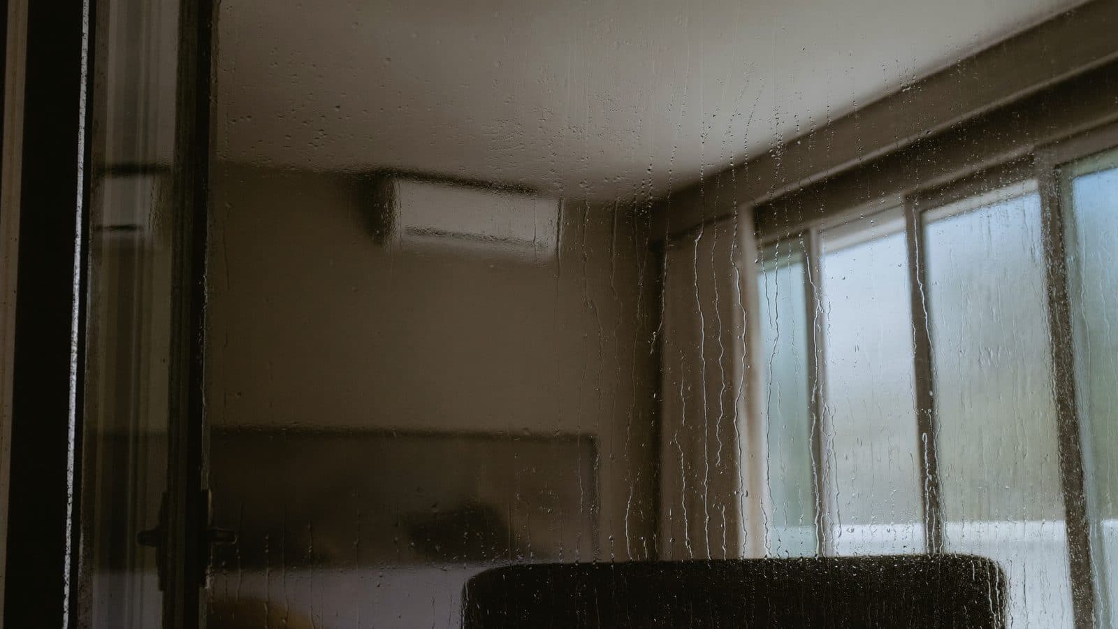 Condens op het raam van een Nederlandse woonkamer met een split-airco die de lucht ontvochtigt