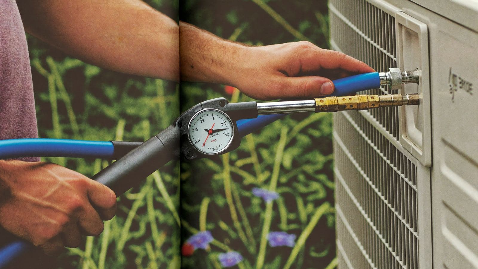 Monteur sluit een vacuümpomp met manometerset aan op de buitenunit van een airco